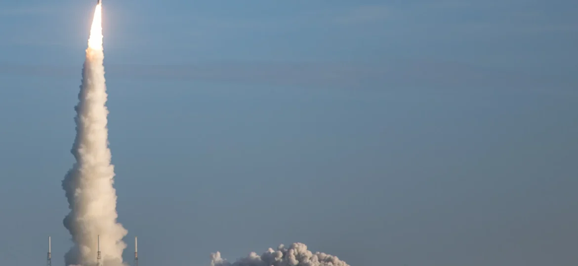 Rocket launching above Cape Canaveral, with the full rocket visible against blue sky